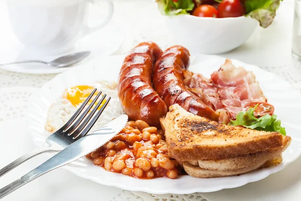 Kompletní anglickou snídani s slanina, klobása, sázené vejce a zapečené — Stock fotografie