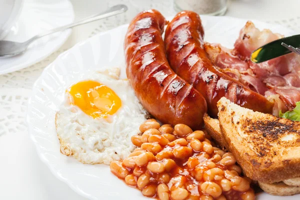 Desayuno inglés completo con tocino, salchichas, huevo frito y frijoles horneados —  Fotos de Stock