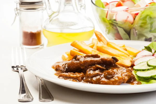 Pork chop with sauce, mushrooms and chips — Stock Photo, Image