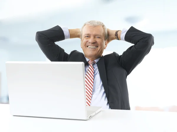 Empresário sorridente inclina-se para trás — Fotografia de Stock