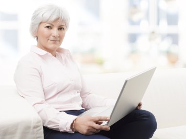 dizüstü bilgisayarda çalışan gülümseyen kadın kıdemli