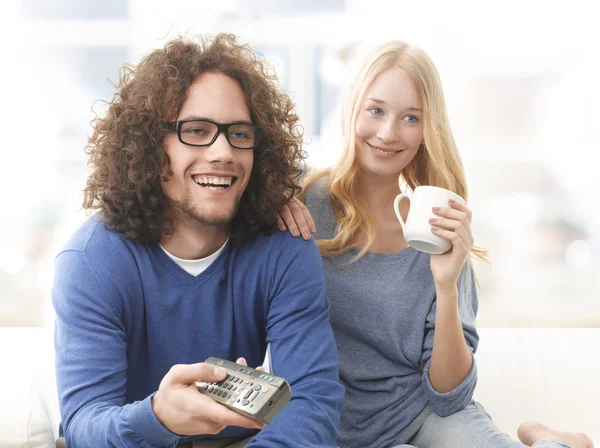 Jong koppel televisie kijken op de Bank — Stockfoto