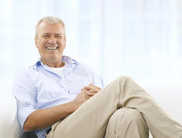 Sonriente hombre mayor en el sofá — Foto de Stock