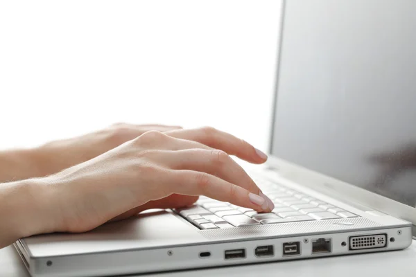 Mãos femininas digitando em um laptop — Fotografia de Stock