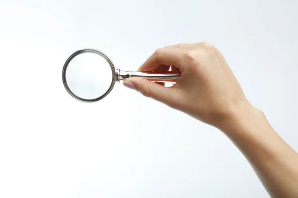 Hand holding a magnifying glass — Stock Photo, Image