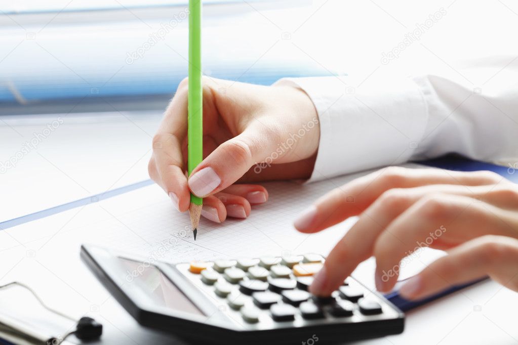 Financial data analyzing. Counting on calculator.