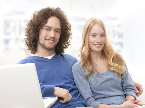 Sereno jovem casal sorridente com laptop — Fotografia de Stock