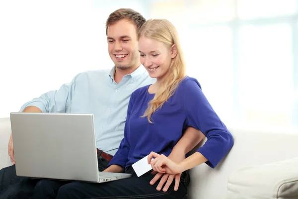 Jovem casal sorrindo compras na internet — Fotografia de Stock