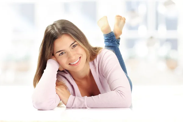 Smiling young brunette lying on floor — Stock Photo, Image