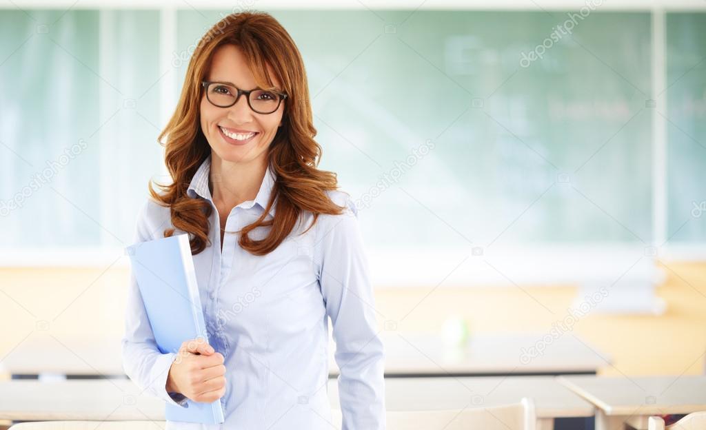 Smiling teacher standing in classroom