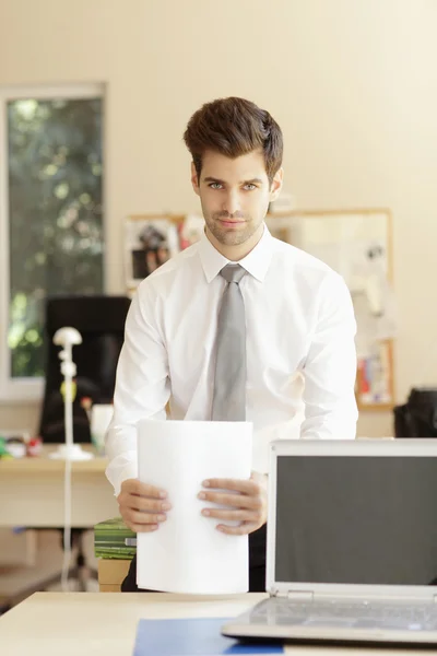 Young businessman standing in office — Stock Photo, Image