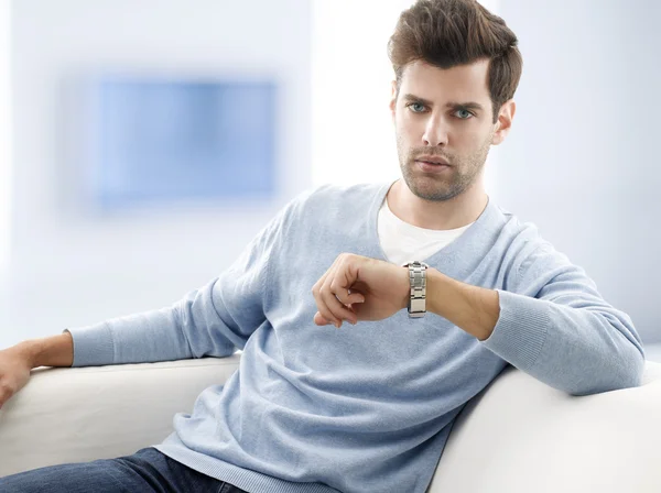 Young man sitting on couch — Stock Photo, Image
