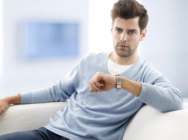 Junger Mann sitzt auf Couch — Stockfoto