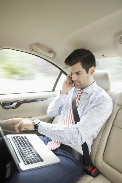 Uomo d'affari con computer portatile nella sua auto — Foto Stock