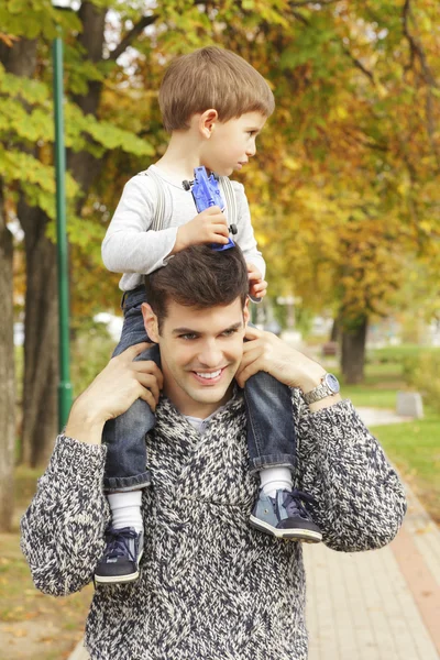 Söt liten pojke ridning piggyback med sin pappa — Stockfoto