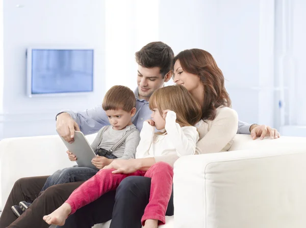 Zittend in de woonkamer en gelukkige familie — Stockfoto