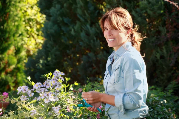 Mature woman taking care of flowers — Stock Photo, Image
