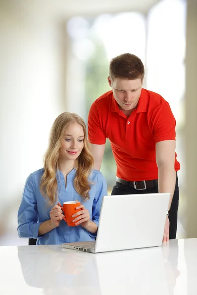 Casal jovem navegando juntos em um laptop — Fotografia de Stock