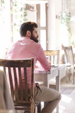 kafede oturan genç adam.