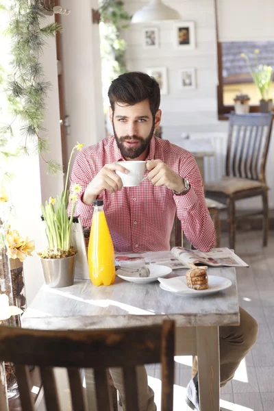 Young man sitting in coffee shop. — Stock Photo, Image