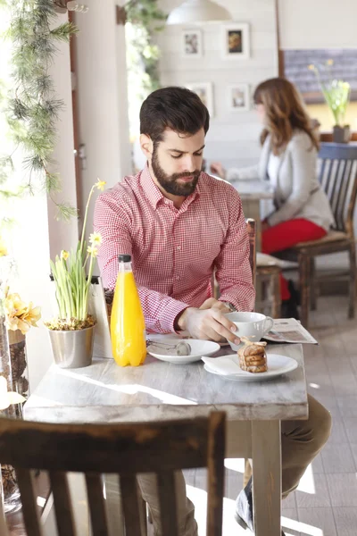 現代の若い男がコーヒー ショップに座っています。 — ストック写真