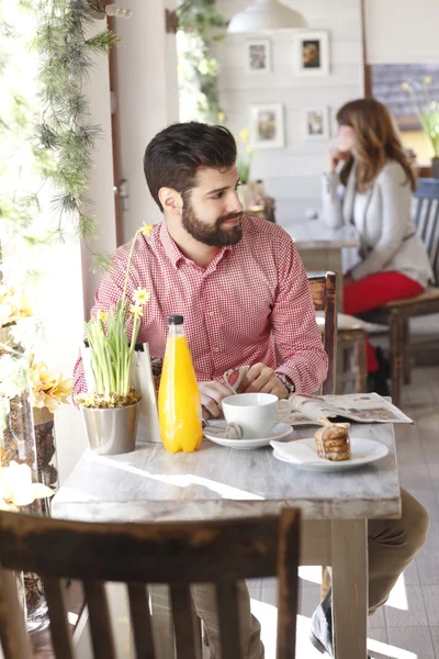 現代の若い男がコーヒー ショップに座っています。 — ストック写真