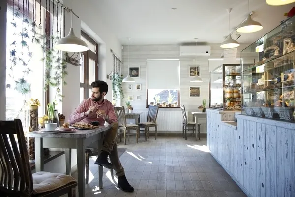 Ung man sitter i kafé. — Stockfoto