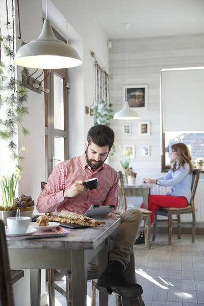 Jonge man zit in koffie winkel — Stockfoto