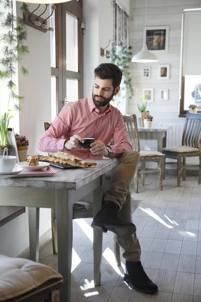 現代の若い男がコーヒー ショップに座っています。 — ストック写真