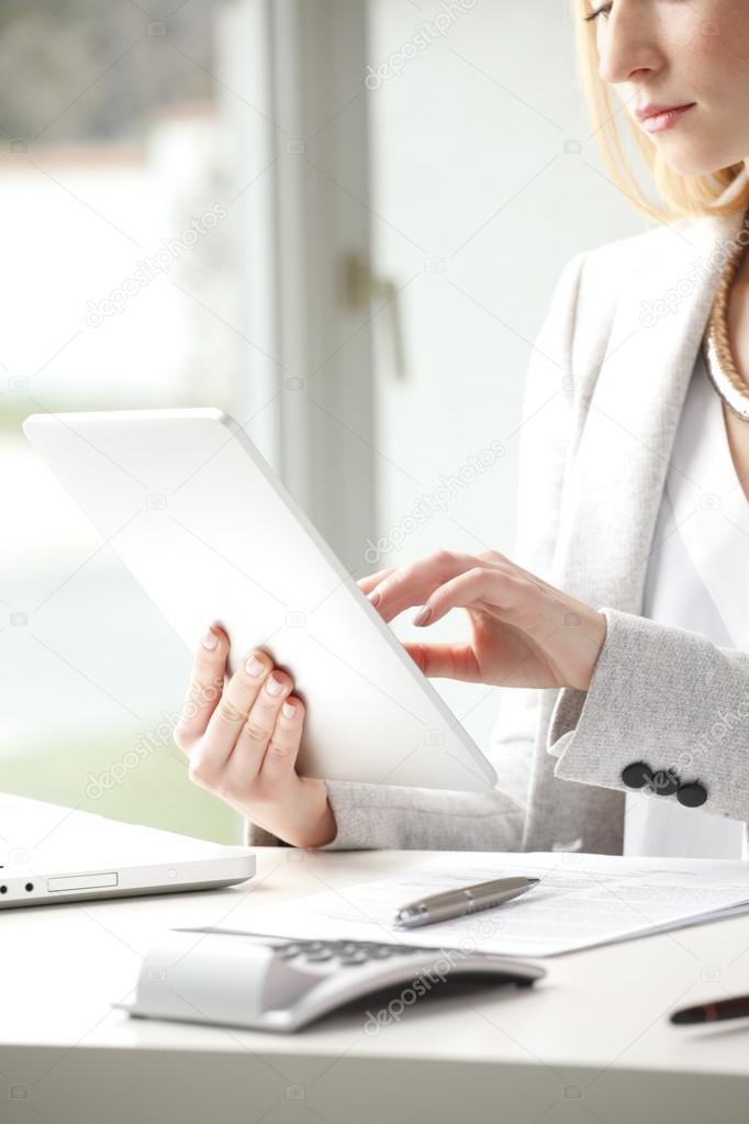 Businesswoman is typing on her tablet