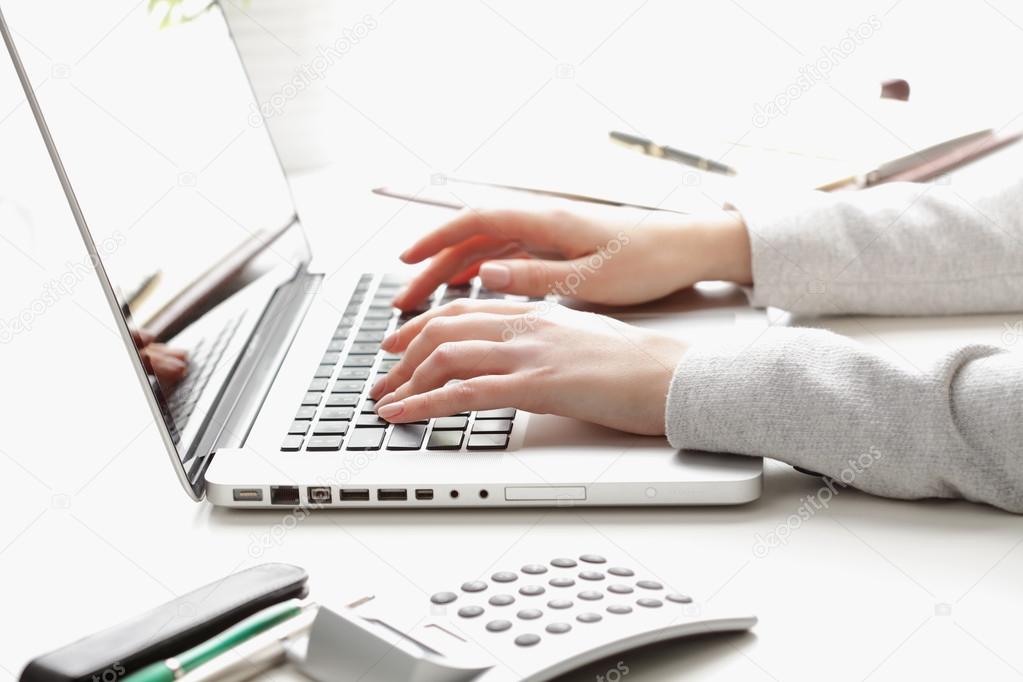 Businesswoman working on laptop and calculating data