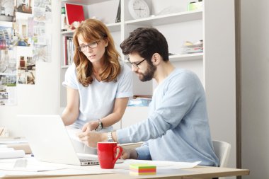 Dizüstü bilgisayarda çalışan iş arkadaşları