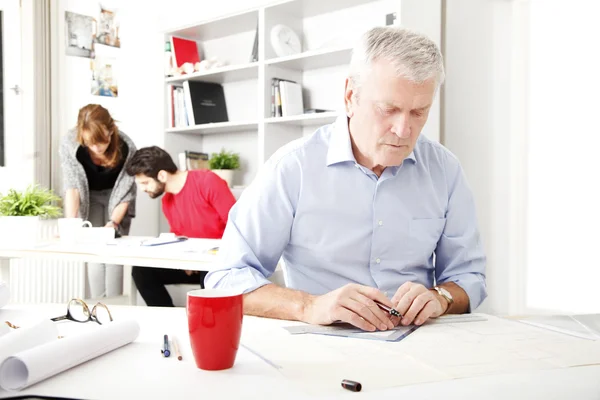 Senior architect working in studio — Stockfoto