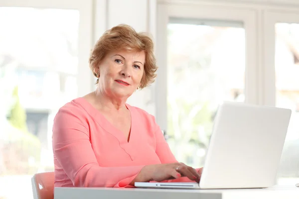 Senior kvinna som arbetar på bärbar dator — Stockfoto