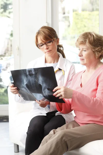 Female doctor analysing x-ray — Stock Photo, Image