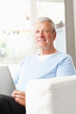 Dizüstü bilgisayarda çalışan kıdemli iş adamı