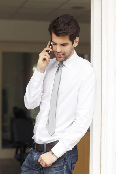 Businessman at office and using his smartphone — Stock Photo, Image