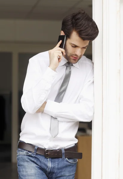 Zakenman aan het Bureau en het gebruik van zijn smartphone — Stockfoto