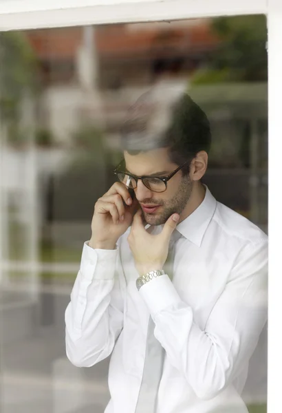 Zakenman achter venster met behulp van zijn handig — Stockfoto