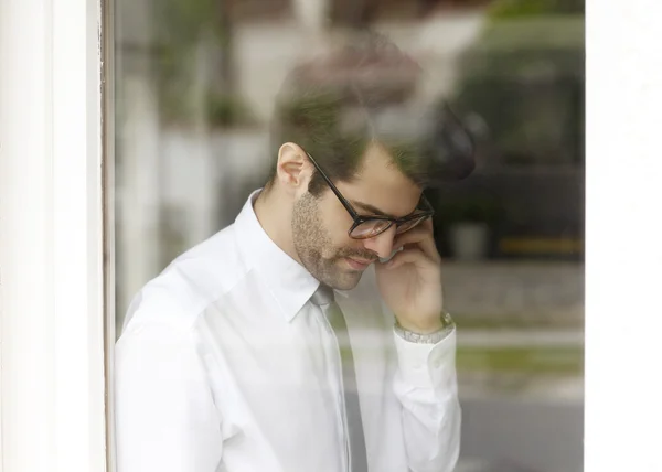 Empresario detrás de la ventana usando su teléfono inteligente — Foto de Stock