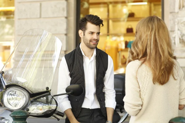 Бізнесмен з скутером обговорює з жінкою — стокове фото