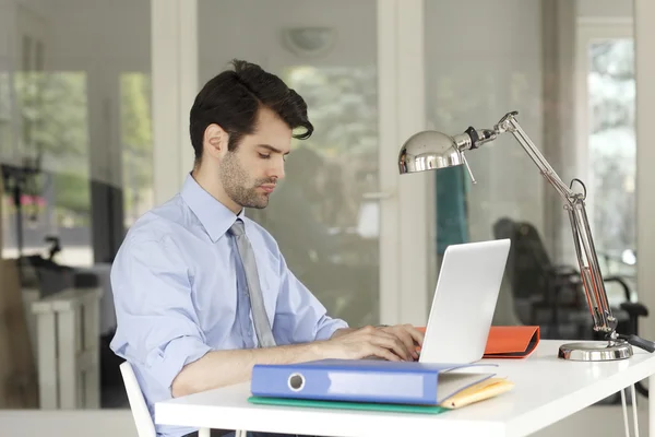 Empresário no escritório trabalhando no laptop — Fotografia de Stock