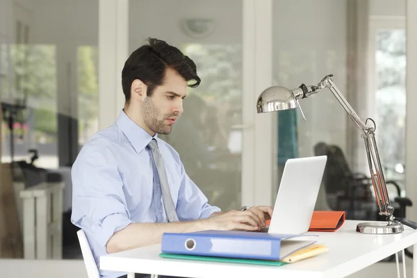 Empresário no escritório trabalhando no laptop — Fotografia de Stock