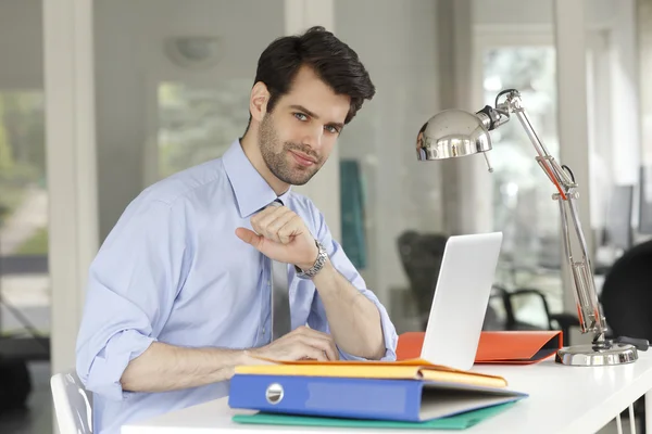 Бизнесмен в офисе работает над ноутбуком — стоковое фото