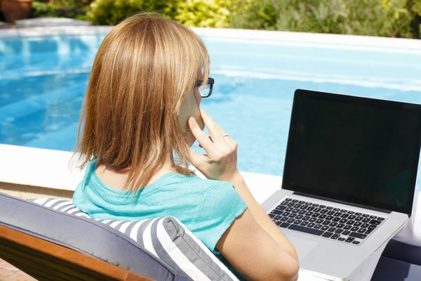 Kvinna på garden med telefon och laptop — Stockfoto