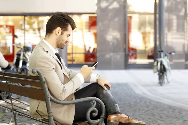 Бизнесмен с телефоном перед бизнес-центром — стоковое фото