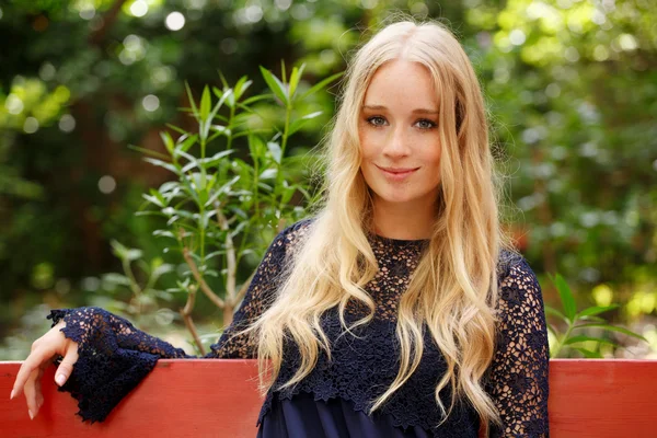 Blondine sitzt im Park — Stockfoto