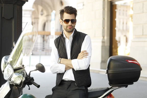 Businessman sitting on scooter at the city — Stock Photo, Image