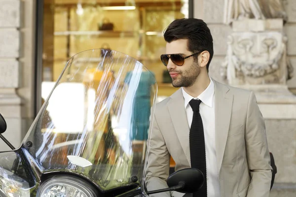 Businessman sitting on scooter at the city — Stock Photo, Image