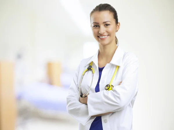 Médico sorrindo com os braços cruzados — Fotografia de Stock